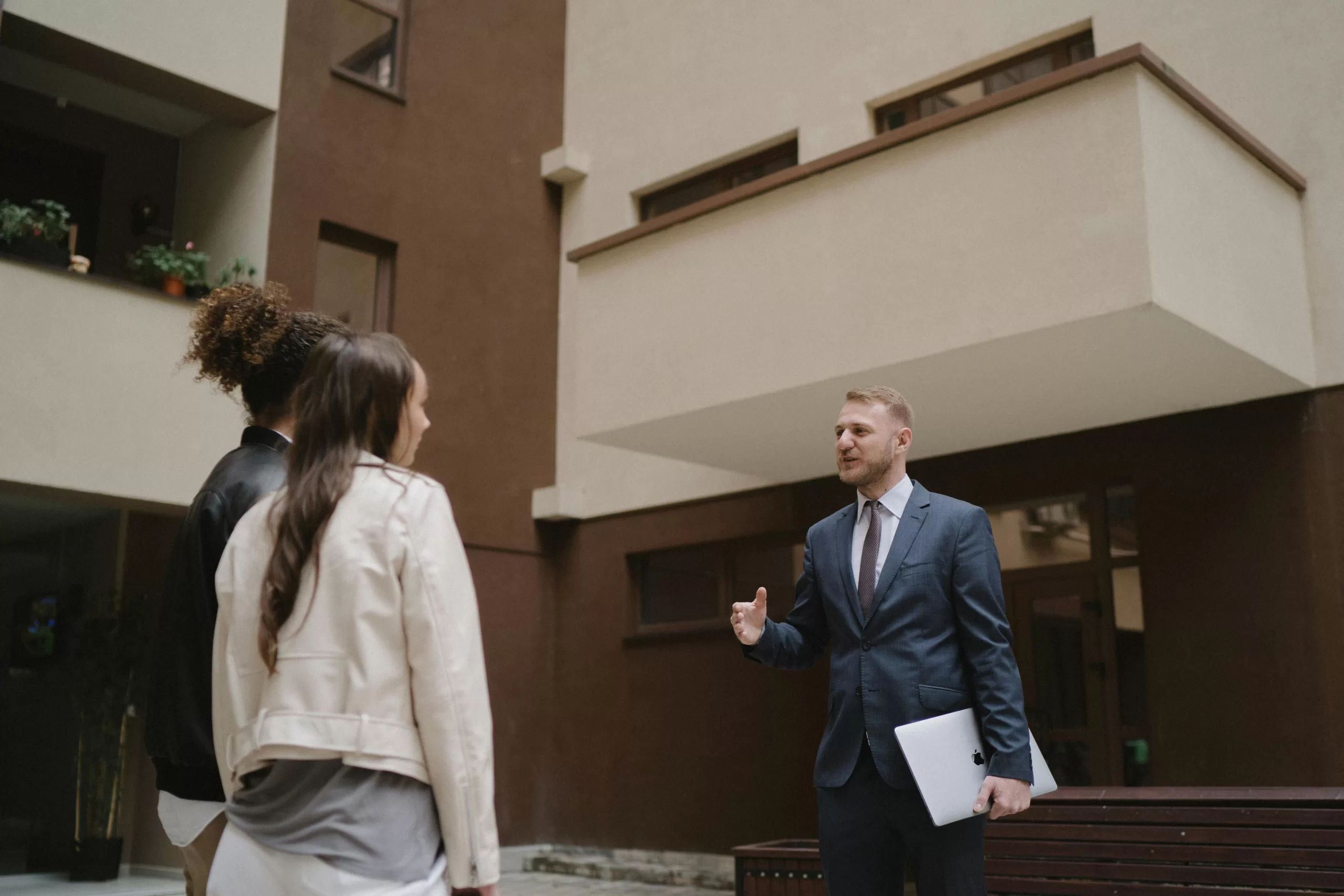 A real estate agent shows an apartment to a couple, illustrating a property tour experience.