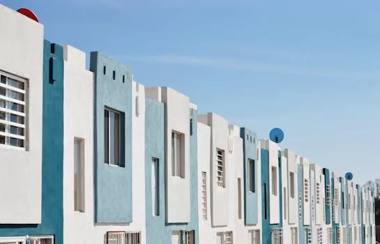 Geometric blue and white facade of a modern apartment building under a clear sky.