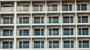 Contemporary facade with glass balconies and uniform window design.