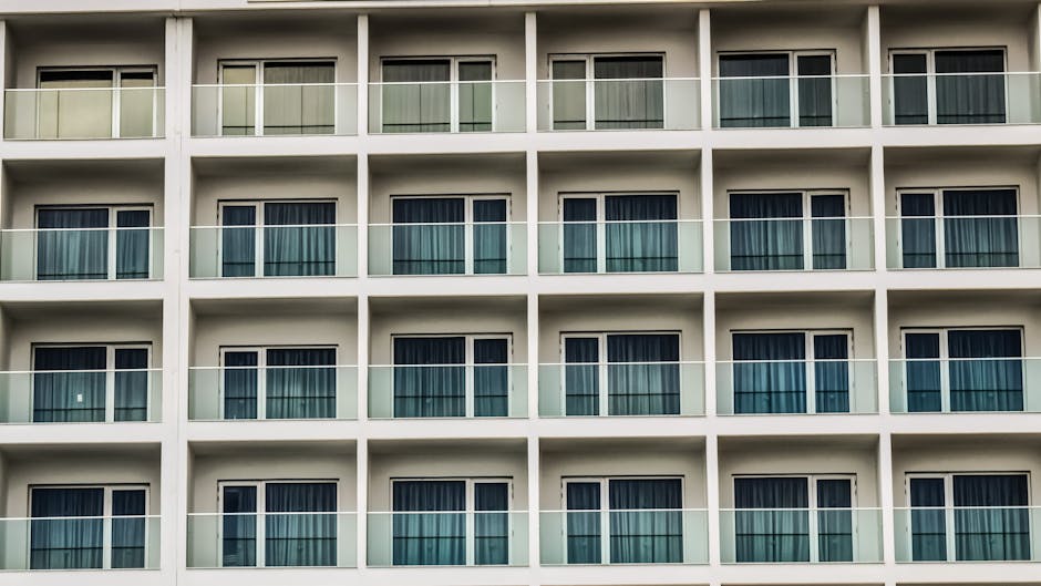 Contemporary facade with glass balconies and uniform window design.