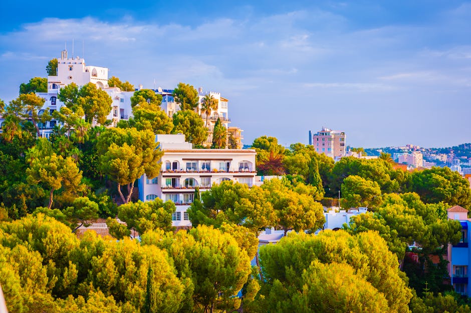 Beautiful hillside villas surrounded by greenery under a vibrant sky.