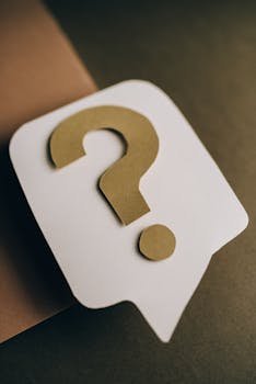 Calculadora de ISR por Enajenación (Venta) de Inmuebles 1 Artistic paper craft of a question mark symbol on a textured green surface. Ideal for conceptual projects.